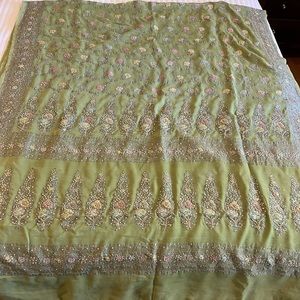 Green gorgette saree with multi colored thread embroidery.
